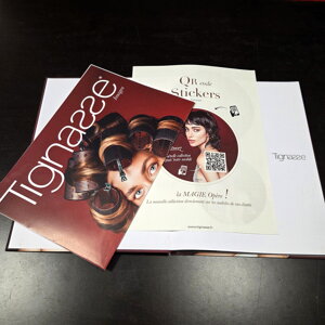 Livre de coiffure B2B ouvert avec encartage sur mesure d'une brochure et de stickers promotionnels